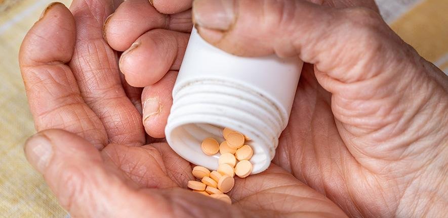 Elderly Woman's Hands and Orange Pills