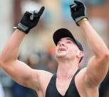 A marathon runner celebrates the moment he crosses the marathon finish line