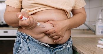 Obese woman injecting weight-loss drug into abdomen